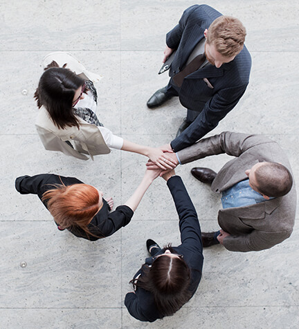 group of people standing with hands together