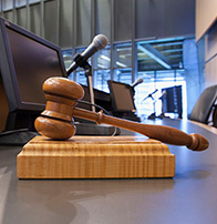 judge's gavel on desk with microphone and monitor
