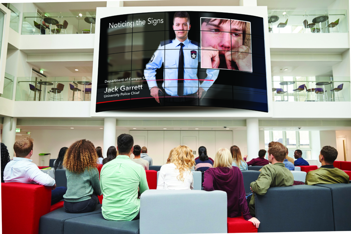 Students watching big screen in university atrium, back view Students watching big screen in university atrium, back view