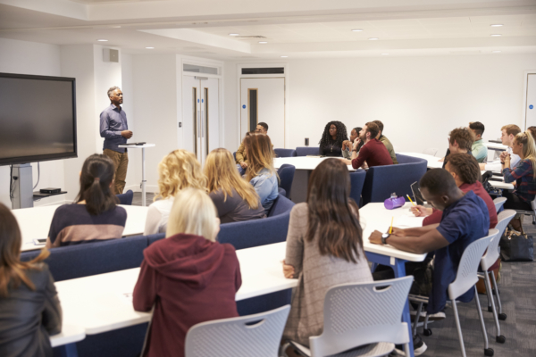 University students study in a classroom with male lecturer students in a college classroom answering questions