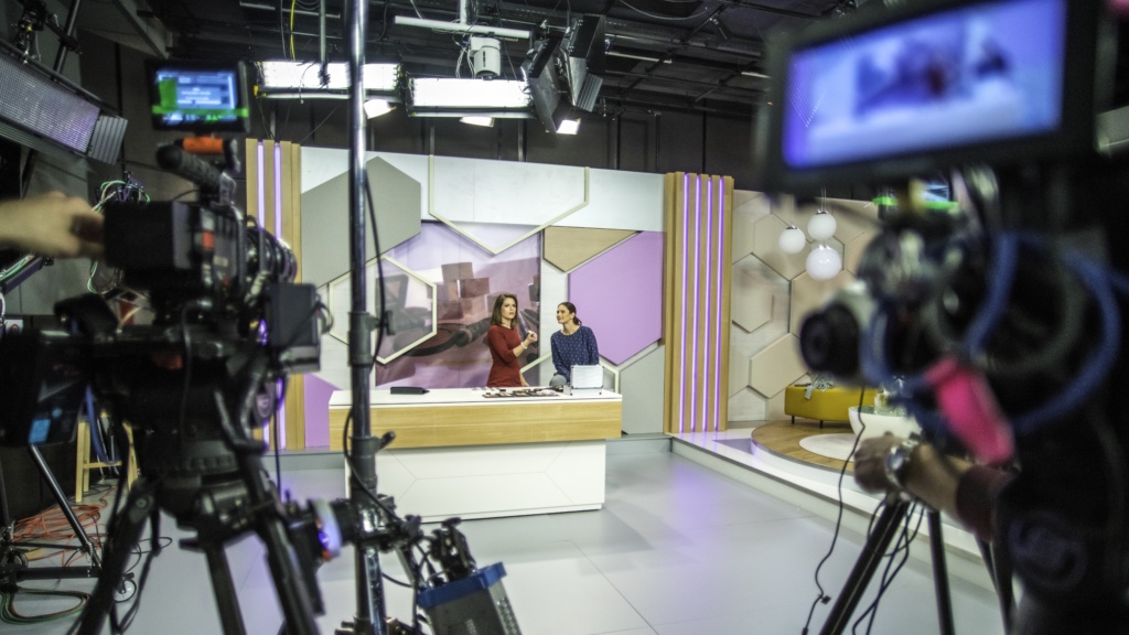 Photo of video recording equipment and stage in a broadcasting studio during the filming of a TV show.